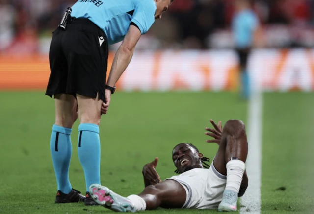 Tottenham Hotspur's Yves Bissouma reacts as referee Felix Zwayer looks on
