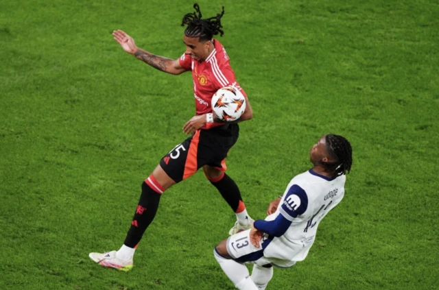 Manchester United's Leny Yoro and Tottenham Hotspur's Destiny Udogie (right) battle for the ball