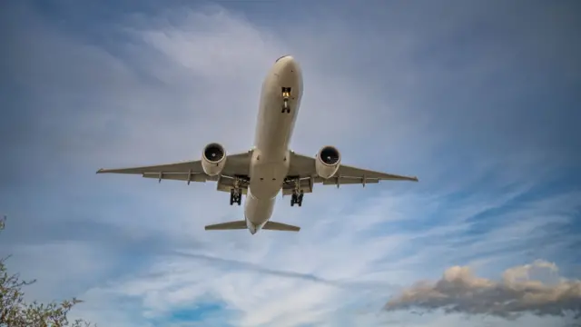 A plane flying through blue skies