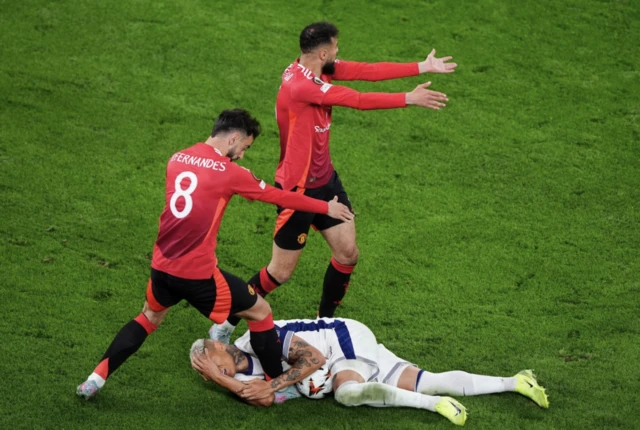 Tottenham Hotspur's Richarlison (on floor) as Manchester United's Bruno Fernandes and Noussair Mazraoui appeal