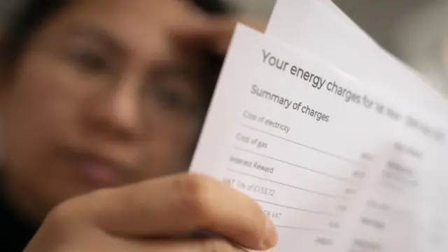 A woman inspecting a bill with her head in her hands