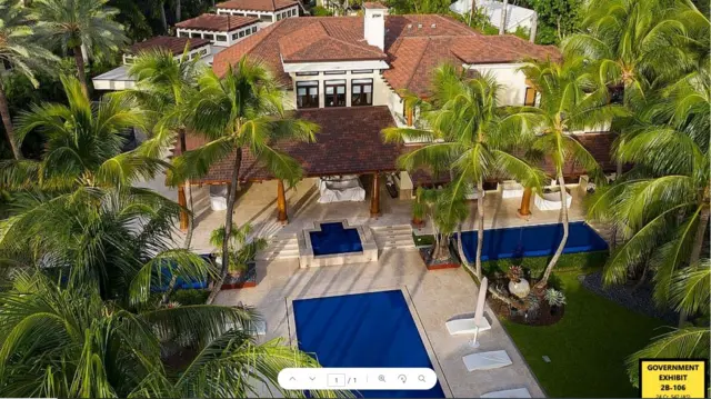 An overhead shot showing a mansion with three swimming pools and surrounded by palm trees