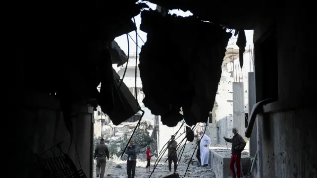 Palestinians inspect the site of an Israeli strike on a house, in Jabalia, northern Gaza Strip.