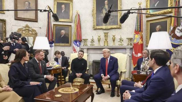 US President Donald Trump meets with Ukrainian President Volodymyr Zelensky in the Oval Office flanked by senior officials from both countries and journalists.