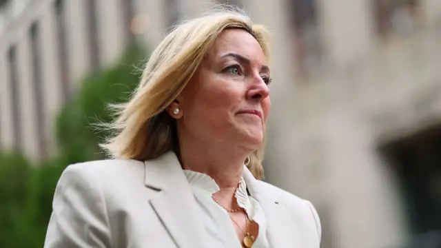 A low-angle shot of Dawn Hughes as she looks ahead and walks