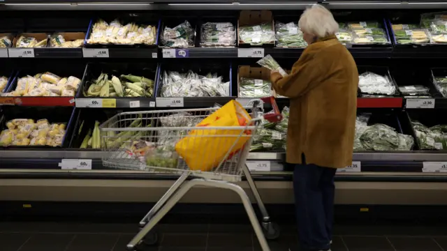 A customer looks at fresh produce inside a Sainsbury's