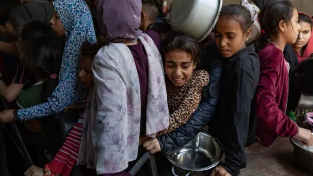 Displaced Palestinians gather outside a charity in Gaza City to receive food rations. Photo: 21 May 2025
