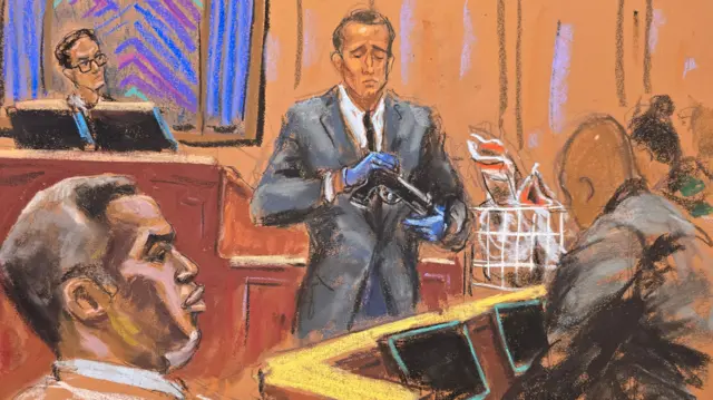 Homeland Security Investigations Special Agent Gerard Gannon holds a firearm with the judge looking on and members of the jury watching