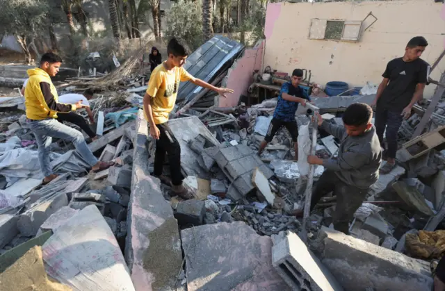 Palestinians inspect the damage at the site of an Israeli strike on a house, in Deir Al-Balah in the central Gaza Strip, May 21, 2025.
