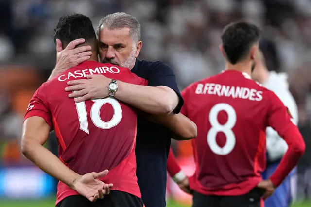Tottenham Hotspur's Greek-Australian Head Coach Ange Postecoglou hugs Manchester United's Brazilian midfielder #18 Casemiro