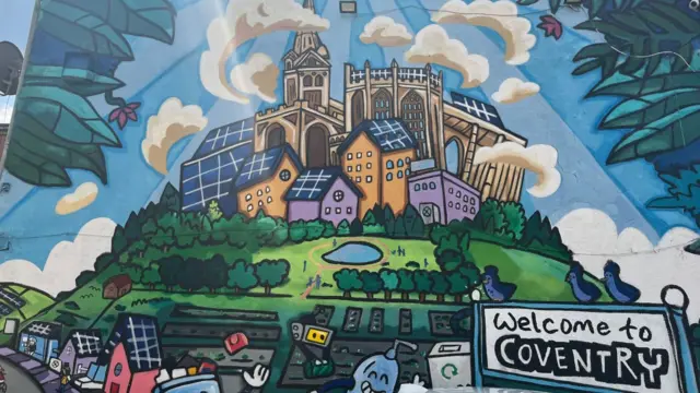 Mural with an illustration of Coventry and sign saying 'welcome to Coventry'