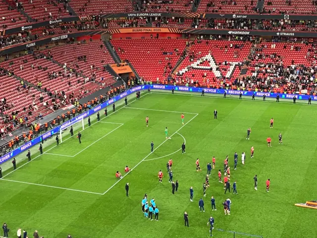 Manchester United players stand on pitch