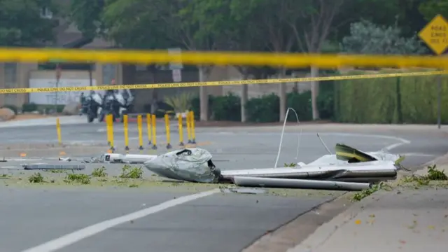 parts of a small civilian aircraft  on the floor within police cordoning
