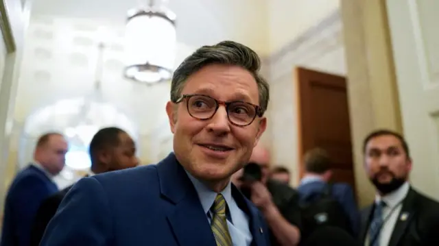 Speaker Mike Johnson looks to the left of the camera and smiles