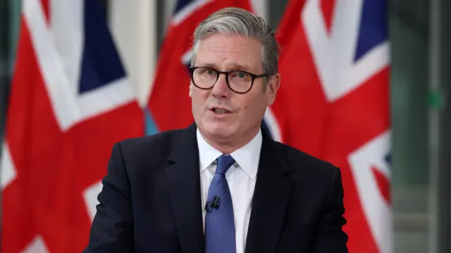 Starmer speaks in front of a Union Jack flag