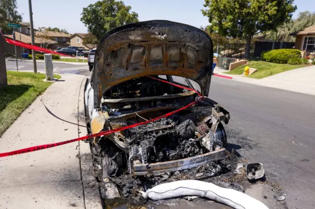The boot of a car completely burnt and destroyed on a suburban street