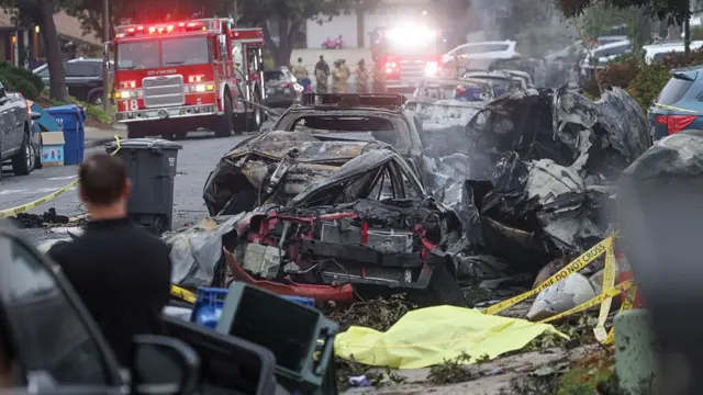 A line of burnt out cars on a residential street
