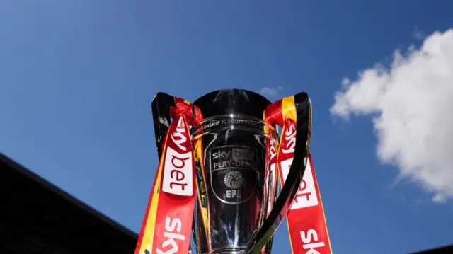 Silver trophy with ribbons tied to handles