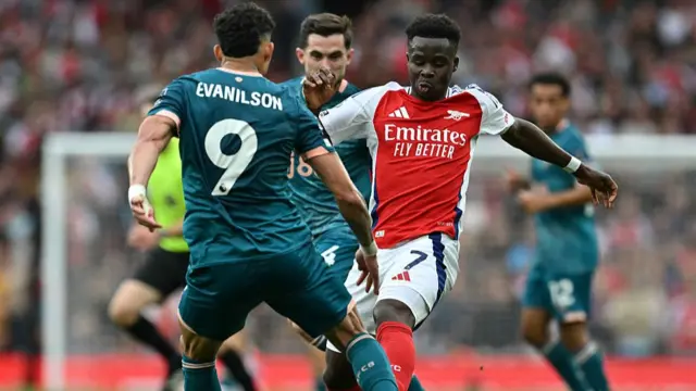 Evanilson and Saka contest for the ball
