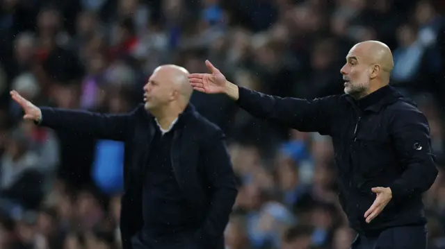 Liverpool manager Arne Slot and Manchester City manager Pep Guardiola signal to their players