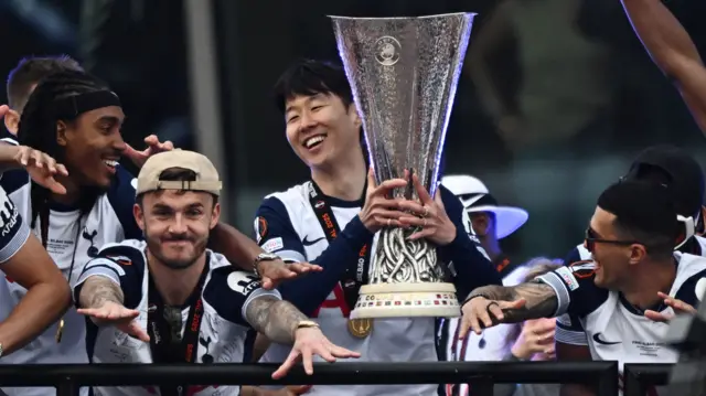 Tottenham Hotspur's Son Heung-min lifts the trophy with other Spurs players stood next to him