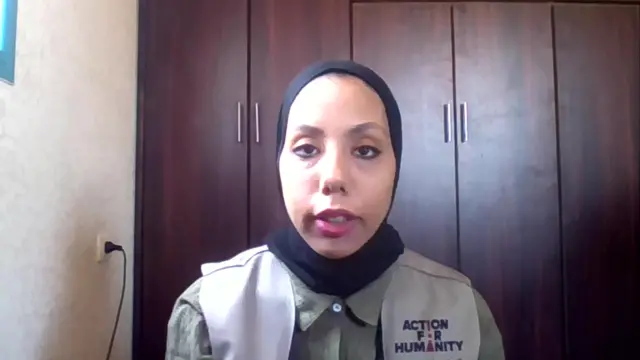 Headshot of woman speaking in front of wooden wardrobes