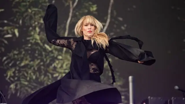Natasha Bedingfield, wearing all black, dances on stage