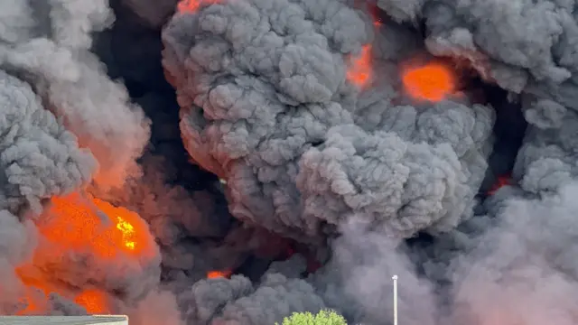 A wall of billowing smoke and glowing fire