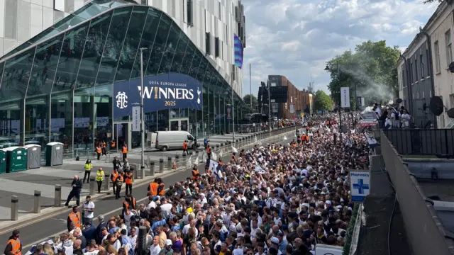 Thousands of fan are seen outside the Tottenham Hotspur Stadium awaiting for the parade. A banner above the stadium entrance states: winners