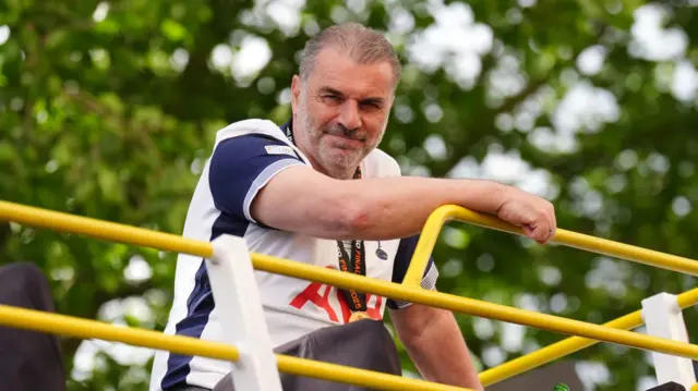 Ange Postecoglou seen looking down from the team bus.
