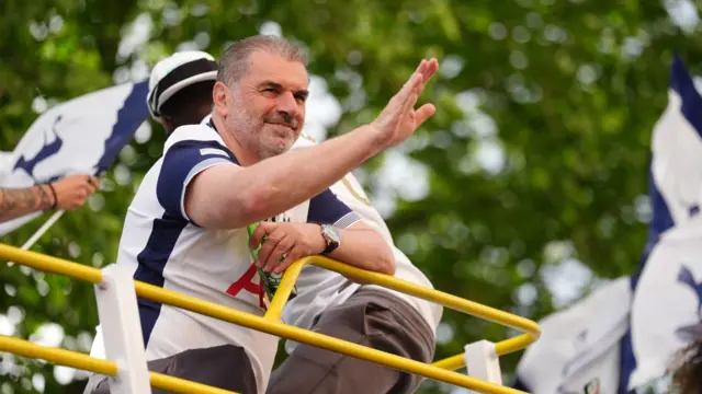 Tottenham Hotspur manager Ange Postecoglou waving from the open-top team bus during the Europa League winners parade