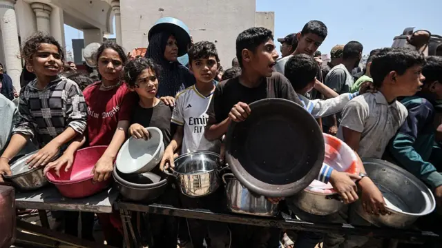 Gazans wait for aid holding buckets