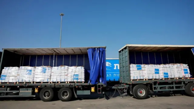 Trucks carrying aid line up at the Kerem Shalom crossing between Israel and Gaza