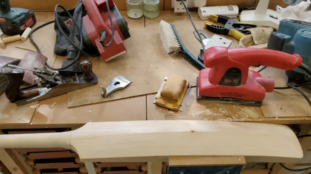 A bat held in a vice on a workbench