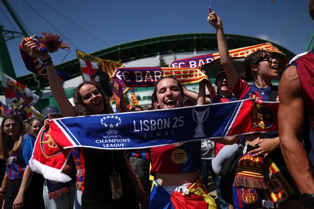 Fans cheer and wave flags as they arrive at the stadium