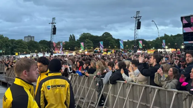 Crowds stand behind a barrier to watch Sam Fender perform on the Main Stage at Big Weekend.