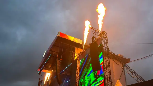 Two flames go up into the sky from the top of the stage.