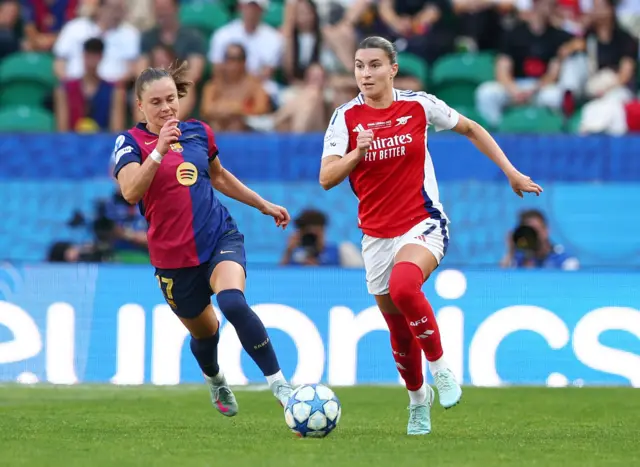 Catley runs out of defence with the ball as Pajor chases
