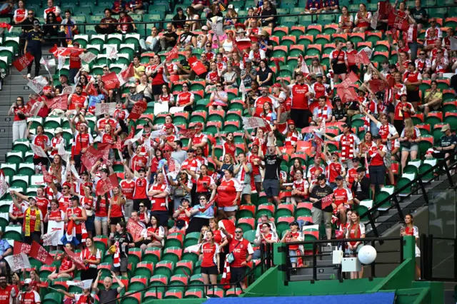 Arsenal fans sit in the stands ahead of the game