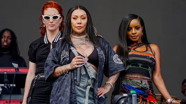 Sugababes pose while singing on the Main Stage at Big Weekend. One of them has red hair and two have long brown hair.