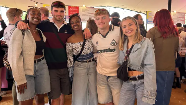 Five members of the Race Across the World TV programme pose for the camera at Big Weekend. There are three women, two who have brown hair and brown eyes and one who has blonde hair and blue eyes. There are two boys, one who has blonde hair and blue eyes and the other has brown hair and blue eyes.