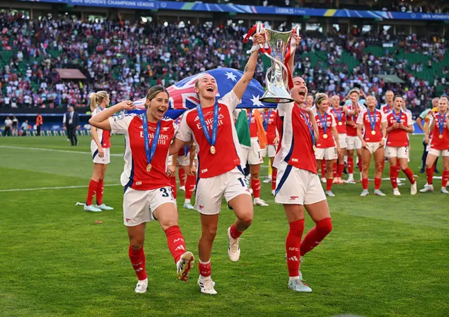 Australian arsenal players lift the trophy in front of the fans