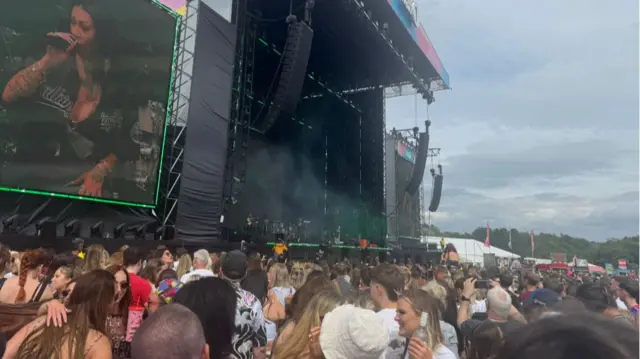 Sugababes performing on stage, crowd watching standing up.
