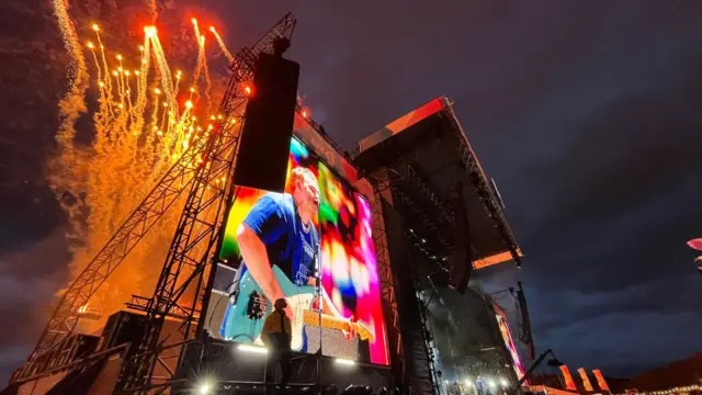 Fireworks above stage, Sam Fender performing.