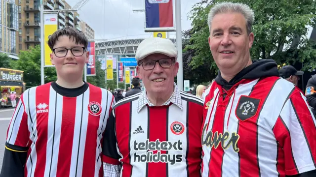 Three Sheffield Untied fans, stood in football shirts on Wembley Way.