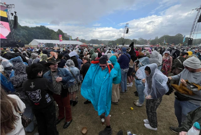 People in a crowd, putting ponchos on.