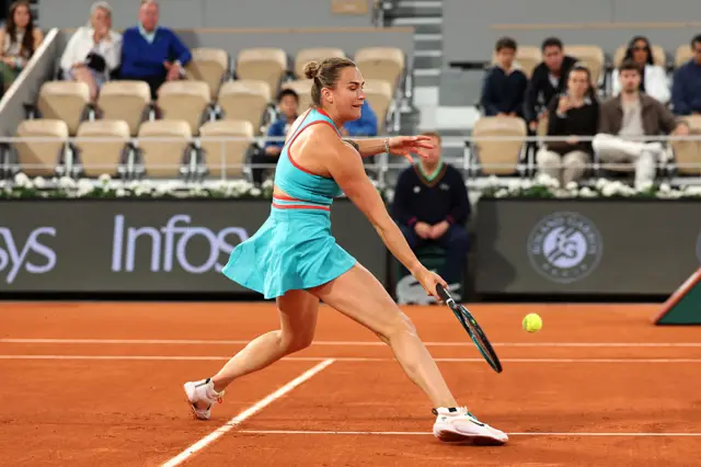 Aryna Sabalenka slides to meet the ball