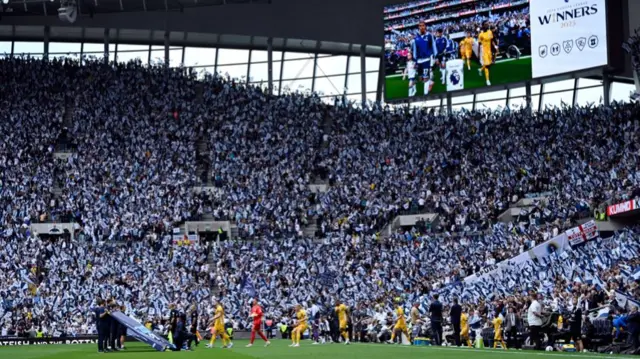 Tottenham fans wave flags as the teams come on to the field for their game against Brighton