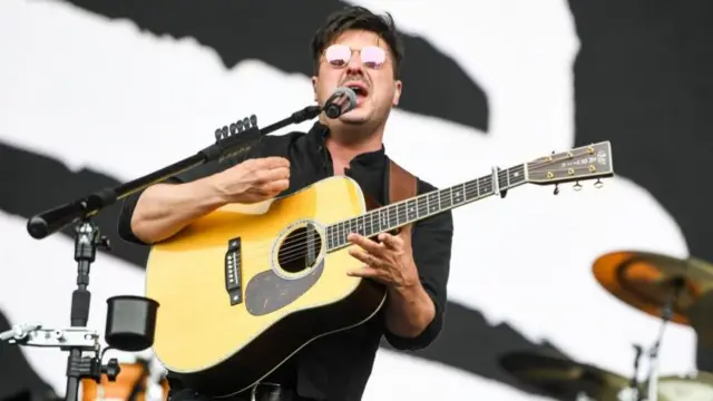 The singer from Mumford and Sons performing on stage