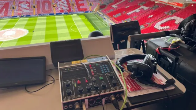 Commentary box showing equipment laid out on a table at Anfield